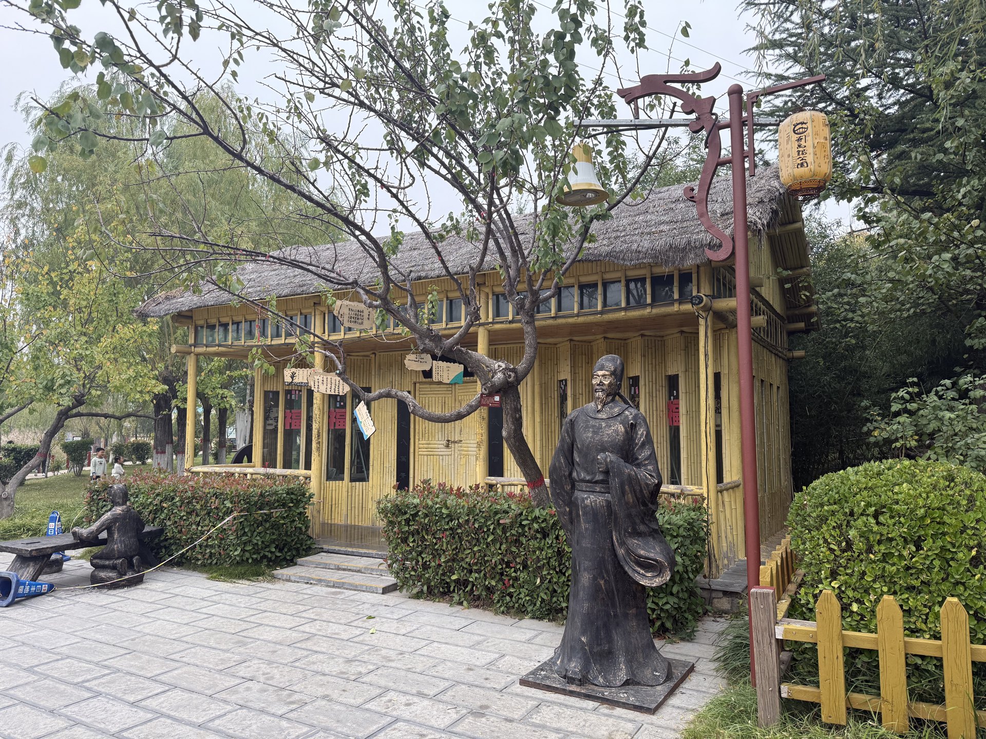 荥阳刘禹锡公园内的陋室展示建筑、树木与人物塑像